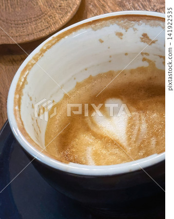 Heart Shape in Leftover Coffee Foam Inside Cup. Heart shape remains in creamy coffee foam inside nearly finished cup. Close-up cafe scene represents love, coffee break, romance, small everyday moments Heart Shape in Leftover Coffee Foam Inside Cup. Heart shape remains in creamy coffee foam inside nearly finished cup. Close-up cafe scene represents love, coffee break, romance, small everyday moments 141922535