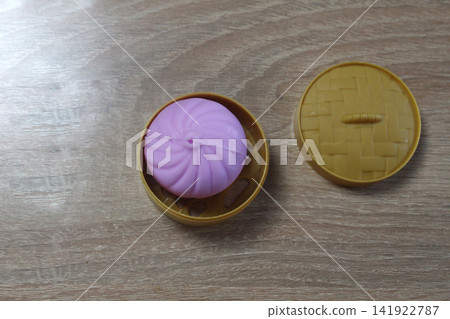 Anti-stress toy dumpling in yellow case top view. Anti-stress toy dumpling in yellow case top view. 141922787