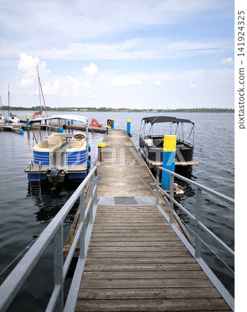 Wooden pier with moored pontoon boats on the lake. Bitterfeld, Goitzsche 141924325