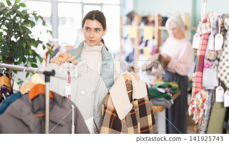 Armenian woman choosing outerwear in the store Armenian woman choosing outerwear in the store 141925743