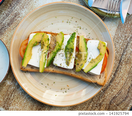 Veggie sandwich with ripe tomatoes, avocado, and mozzarella Veggie sandwich with ripe tomatoes, avocado, and mozzarella 141925794
