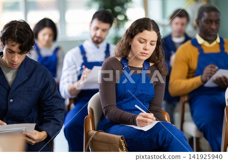 In lecture, girl employee writes on large piece of paper In lecture, girl employee writes on large piece of paper 141925940