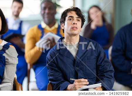 During lecture meeting, young man worker listen to teacher and write down summary During lecture meeting, young man worker listen to teacher and write down summary 141925982