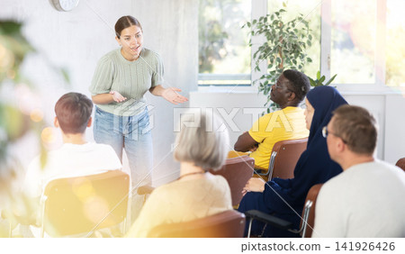 Young female teacher giving lecture to group of multinational students Young female teacher giving lecture to group of multinational students 141926426