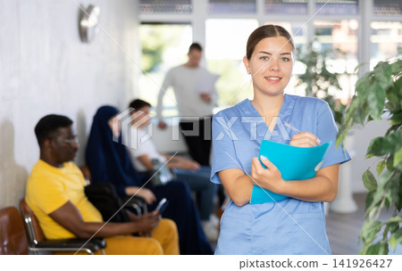 Young woman in medical uniform making notes Young woman in medical uniform making notes 141926427