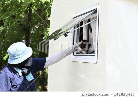 一位女士喜歡帶著她的狗——傑克羅素梗犬——開著露營車去露營。 一位女士喜歡帶著她的狗——傑克羅素梗犬——開著露營車去露營。 141926435