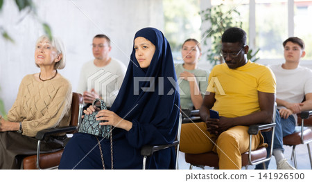 Positive multinational students listening to lecture in classroom Positive multinational students listening to lecture in classroom 141926500