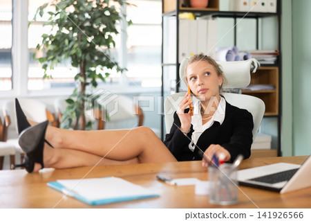 Elegance businesswoman sitting in office at workplace talking on phone Elegance businesswoman sitting in office at workplace talking on phone 141926566