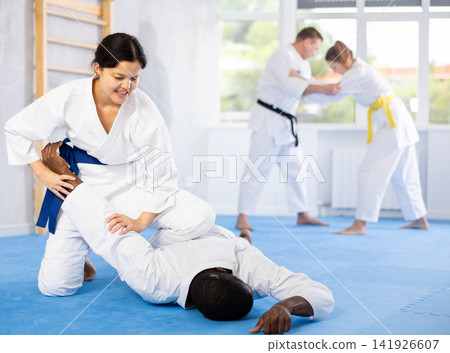 Adult man and young woman training judo techniques Adult man and young woman training judo techniques 141926607