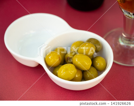 Closeup of plate of pickled green olives with stone, spanish appetizer 141926626