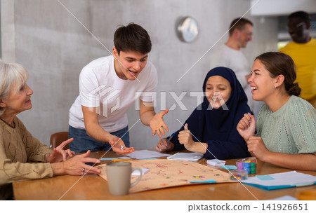 Group of multinational people playing board game Group of multinational people playing board game 141926651