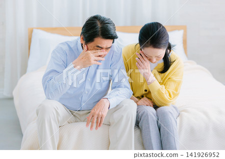 A couple holding their heads in despair - a negative image A couple holding their heads in despair - a negative image 141926952