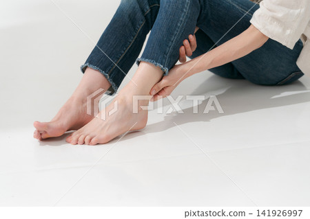 Women rubbing their feet Women rubbing their feet 141926997