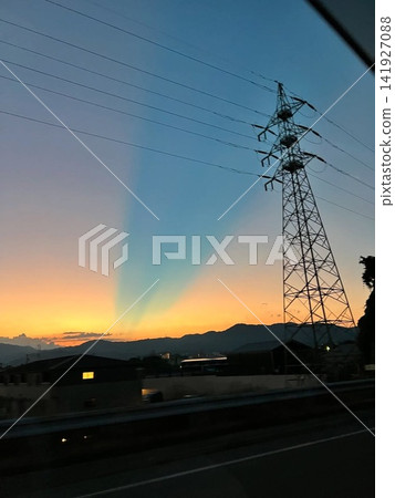 Light and shadows stretching across the sunset sky of Fukuoka, and power transmission towers. Light and shadows stretching across the sunset sky of Fukuoka, and power transmission towers. 141927088