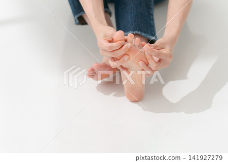 一個女人在摸自己的腳趾 一個女人在摸自己的腳趾 141927279