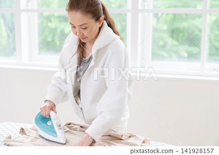 Senior woman ironing Senior woman ironing 141928157
