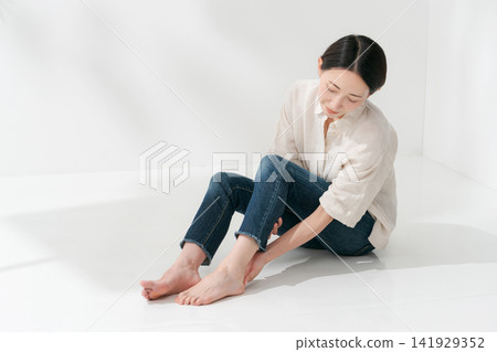 一位女士正在保養她的腳跟 一位女士正在保養她的腳跟 141929352