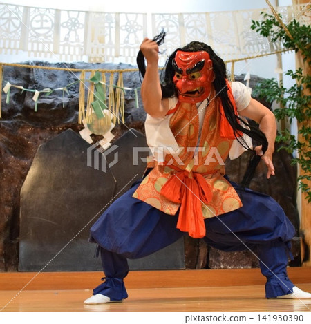 高千穗神樂的動感舞蹈和佩戴神樂面具的傳統表演藝術場景。 高千穗神樂的動感舞蹈和佩戴神樂面具的傳統表演藝術場景。 141930390
