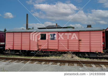 Vintage red cargo boxcar standing on old railway tracks Vintage red cargo boxcar standing on old railway tracks 141930886