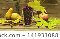 Autumn Still Life. Cranberries in a glass with autumn leaves, apples and pears. 141931088