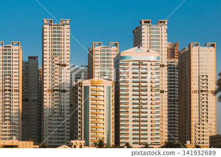 New Residential Multi-storey Houses. Cityscape Skyline In Sunny Spring Evening On Blue Sky. Real Estate, Development Industry. UAE New Residential Multi-storey Houses. Cityscape Skyline In Sunny Spring Evening On Blue Sky. Real Estate, Development Industry. UAE 141932689