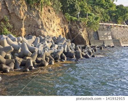 A landscape of tetrapods and breakwaters protecting coastal cliffs from erosion. A landscape of tetrapods and breakwaters protecting coastal cliffs from erosion. 141932915