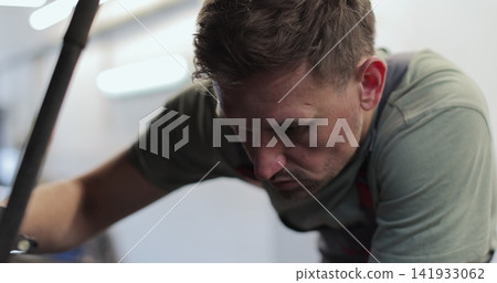 Close up mechanic man with lamp working at workshop. concept car service, repair, maintenance and people. Close up mechanic man with lamp working at workshop. concept car service, repair, maintenance and people. 141933062