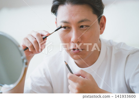 Eyebrow makeup for men in their 40s: drawing eyebrows with an eyebrow brush and eyebrow pencil. Eyebrow makeup for men in their 40s: drawing eyebrows with an eyebrow brush and eyebrow pencil. 141933600