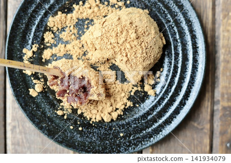自製萩糕(年糕)的橫切面,包覆了烤黃豆粉,以及一根用於日式甜點的竹籤。 自製萩糕(年糕)的橫切面,包覆了烤黃豆粉,以及一根用於日式甜點的竹籤。 141934079