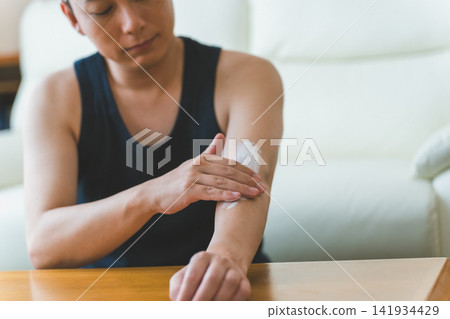 Men's skincare: A 40-year-old man applying a generous amount of cream to his arms. Men's skincare: A 40-year-old man applying a generous amount of cream to his arms. 141934429