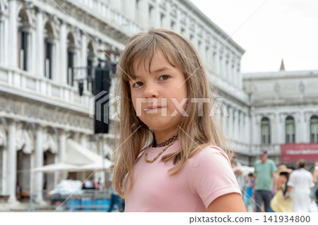 Serious young girl in pink shirt posing before ornate historic building Serious young girl in pink shirt posing before ornate historic building 141934800