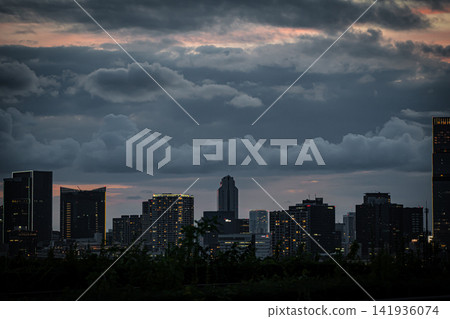 A glittering high-rise apartment building and city night view from the Toyosu waterfront on a summer night. A glittering high-rise apartment building and city night view from the Toyosu waterfront on a summer night. 141936074