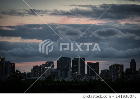 A glittering high-rise apartment building and city night view from the Toyosu waterfront on a summer night. A glittering high-rise apartment building and city night view from the Toyosu waterfront on a summer night. 141936075