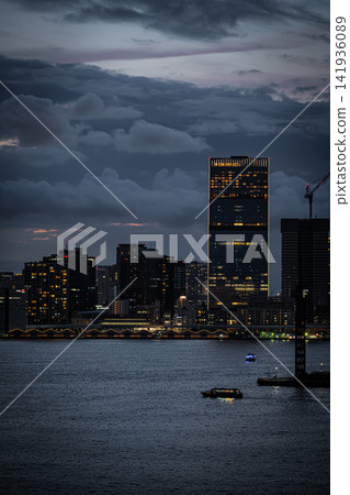 A glittering high-rise apartment building and city night view from the Toyosu waterfront on a summer night. A glittering high-rise apartment building and city night view from the Toyosu waterfront on a summer night. 141936089