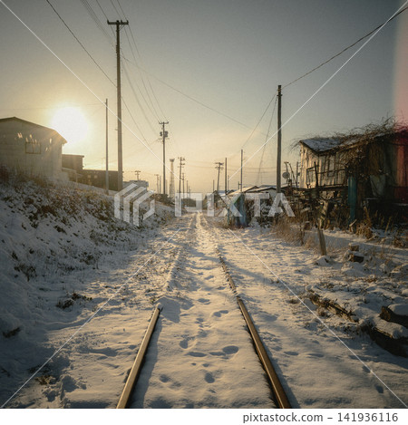 白雪覆蓋的鐵軌蜿蜒穿過漁村的小巷,夕陽西下 | 昭和時代東北地區令人懷念的復古景象 白雪覆蓋的鐵軌蜿蜒穿過漁村的小巷,夕陽西下 | 昭和時代東北地區令人懷念的復古景象 141936116