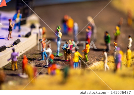 Miniature crowd figures gathering near a small outdoor stage in focus Miniature crowd figures gathering near a small outdoor stage in focus 141936487