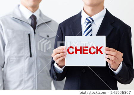 A young businessman in a business suit holding a whiteboard with the word "CHECK" on it. A young businessman in a business suit holding a whiteboard with the word "CHECK" on it. 141936507