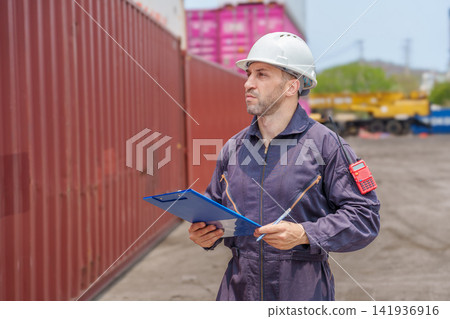 Warehouse supervisor inspecting cargo containers at shipping yard. 141936916
