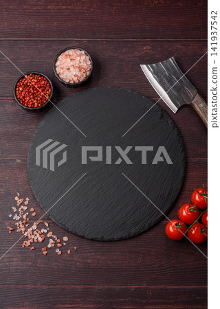 An empty black slate kitchen board for food preparation. An empty slate board serving An empty black slate kitchen board for food preparation. An empty slate board serving 141937542