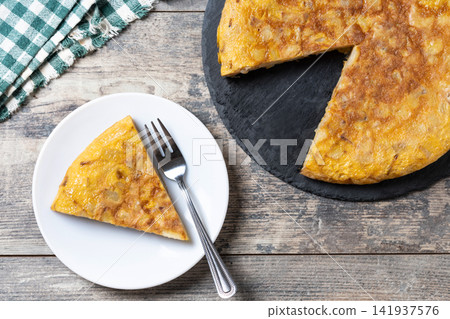 Slice of Traditional Spanish Potato Omelette on wooden table Slice of Traditional Spanish Potato Omelette on wooden table 141937576