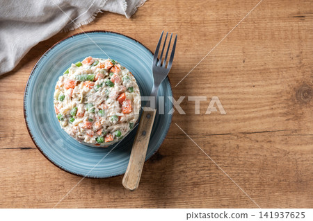 Traditional Russian Salad with Tuna and Vegetables on wooden table. Traditional Russian Salad with Tuna and Vegetables on wooden table. 141937625