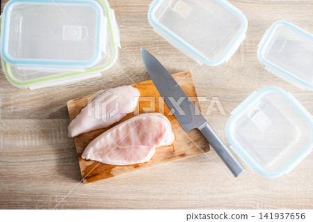Raw Chicken Breasts with Knife on Wooden Cutting Board Raw Chicken Breasts with Knife on Wooden Cutting Board 141937656