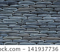 Texture of a fence made of decorative stonework made of gray sea pebbles 141937736