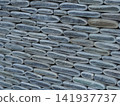 Texture of a fence made of decorative stonework made of gray sea pebbles 141937737