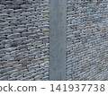 Texture of a fence made of decorative stonework made of gray sea pebbles 141937738