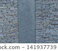 Texture of a fence made of decorative stonework made of gray sea pebbles 141937739