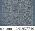 Texture of a fence made of decorative stonework made of gray sea pebbles 141937740