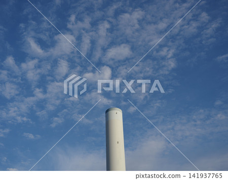 寧靜的城市景觀,一座垃圾焚化廠的煙囪聳立在湛藍的天空下。 寧靜的城市景觀,一座垃圾焚化廠的煙囪聳立在湛藍的天空下。 141937765