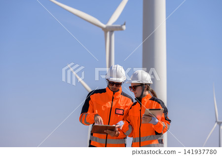 Wind farm technicians conducting turbine inspection at renewable energy power plant Wind farm technicians conducting turbine inspection at renewable energy power plant 141937780