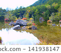 A pond in the mountains where the autumn leaves have begun to change color. 141938147